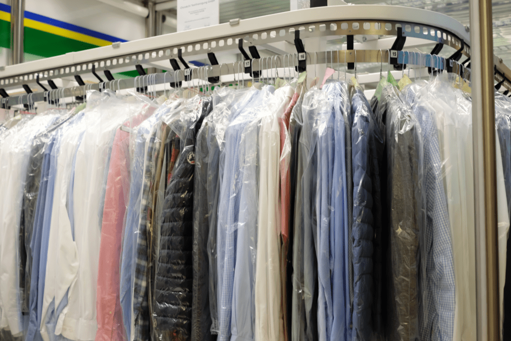 A photo showing different clothes on a dry cleaning rack.