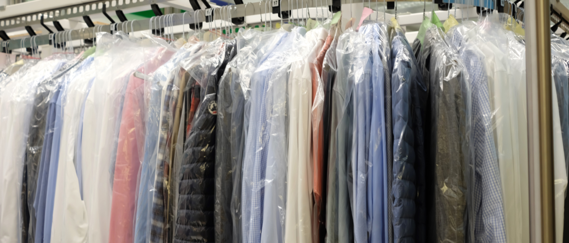 A photo showing different clothes on a dry cleaning rack.